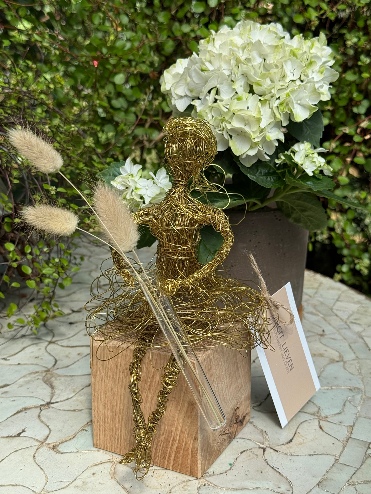 Blumenmädchen auf Holzsockel