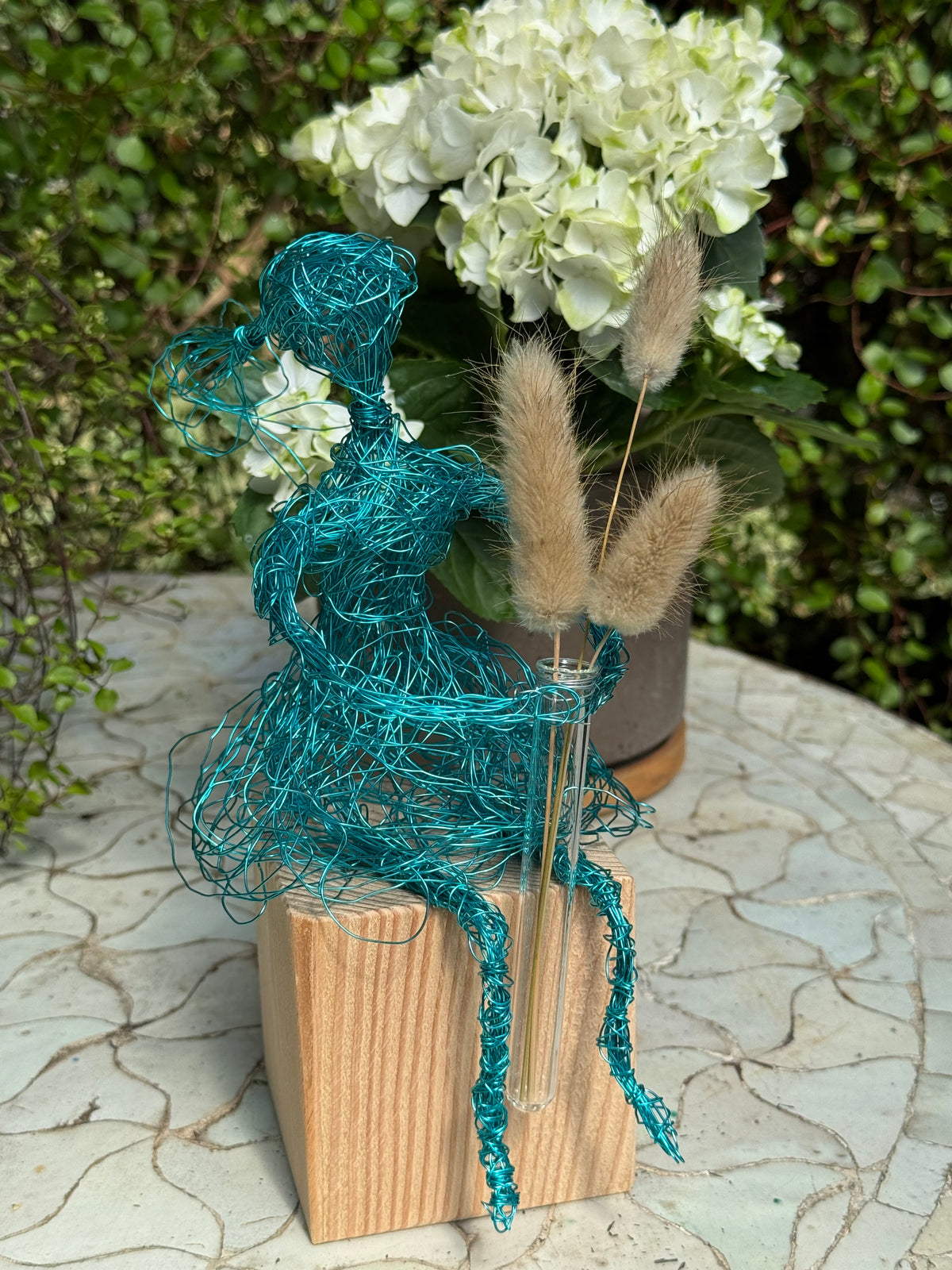 Blumenmädchen auf Holzsockel