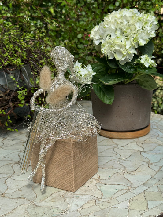Blumenmädchen auf Holzsockel